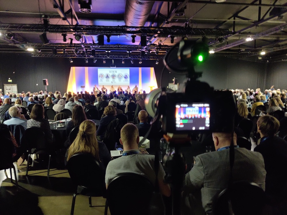 Live event broadcast setup with production screens and streaming equipment.